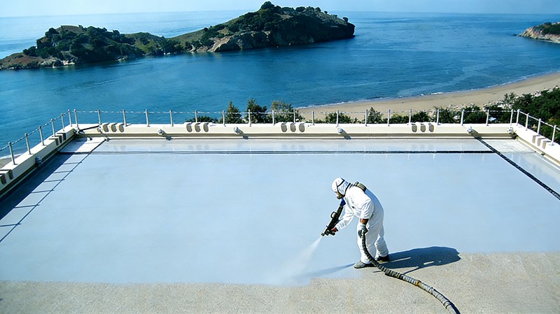Spray polyurea roof waterproofing application on exposed flat roof surface