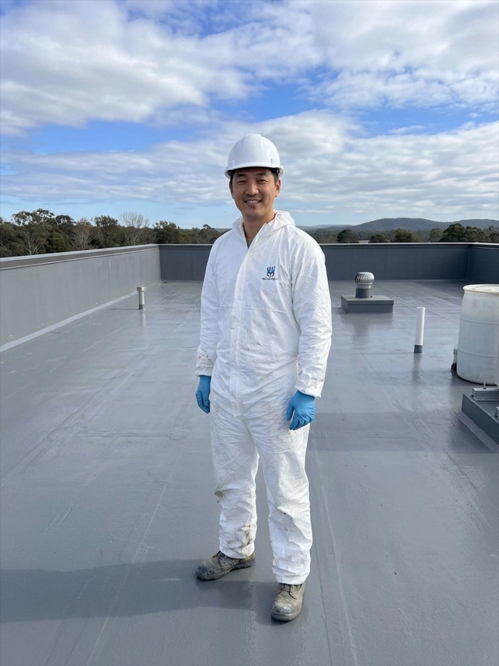 Industrial rooftop with polyurea waterproof coating and technician performing a roof inspection